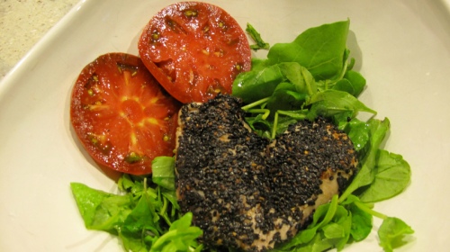 Black sesame encrusted tuna and truffled heirloom tomatoes on bed of arugula.